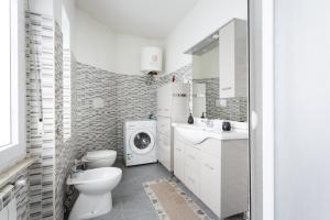 een badkamer met een toilet en een wasmachine bij Appartamento in Cagliari