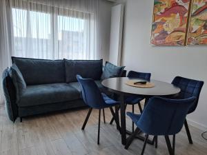 a living room with a couch and a table and chairs at Gardenia Seaside Apartament 34 in Dziwnów