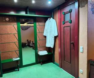 ein Ankleidezimmer mit einem Spiegel und einer roten Tür in der Unterkunft Hotel Veles in Zolotonosha