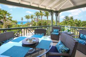 a table and chairs on a balcony with a view of the ocean at Beacon Hill 304 by BSL Rentals in Saint Peter