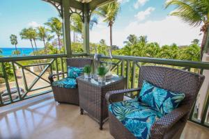 a balcony with two chairs and a table and the ocean at Beacon Hill 304 by BSL Rentals in Saint Peter