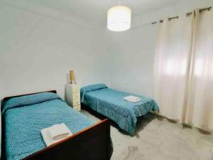 1 dormitorio con 2 camas individuales y vestidor con 1 cama doble en Mar Vendaval Grupo AC Gestion en Cádiz