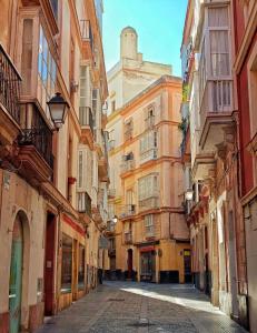 an empty street in an alley between buildings at Mar Vendaval Grupo AC Gestion in Cádiz
