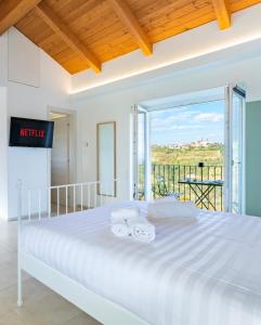 una camera da letto con un grande letto bianco e un balcone di Ca'd Felice - Villa nella natura con vista Langhe a Rodello