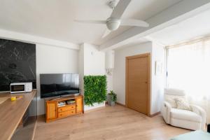 sala de estar con TV de pantalla plana y sofá en Apartamento villa playa, en Benidorm