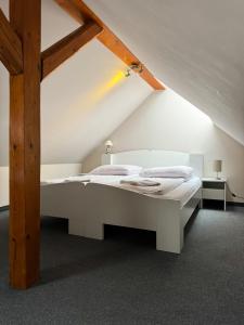 a bedroom with a white bed in a attic at Villa Carmen in Kudowa-Zdrój