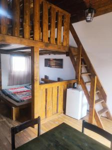 an attic room with a bunk bed and a table at Ubytování v komfortní chatce Štít in Chlumec nad Cidlinou
