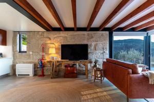 a living room with a couch and a television at Javardo - Family House - Douro in Penha Longa