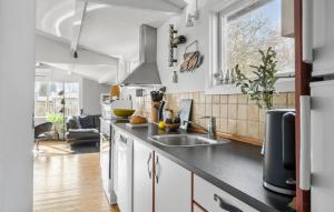 a kitchen with white cabinets and a sink at Two-Bedroom Holiday Home In Jagerspris in Jægerspris +16 photos