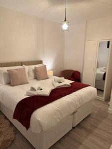 a bedroom with a large bed with towels on it at Sunny Apartment In Cheltenham in Cheltenham
