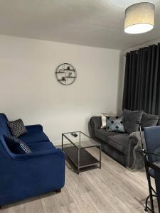 a living room with a couch and a table at Sunny Apartment In Cheltenham in Cheltenham