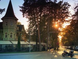 een motorfiets geparkeerd voor een gebouw met een toren bij Pegasa Pils Spa Hotel in Jūrmala