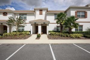 une grande maison blanche avec des palmiers dans un parking dans l'établissement Top Villas - Championsgate 2140, à Davenport