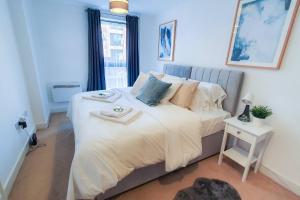 - une chambre avec un grand lit blanc et une fenêtre dans l'établissement Lovely Flat In Kiln Close With Free Parking, à Gloucester