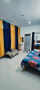 um quarto com uma cama e cortinas coloridas em Advik cottege em Rāmnagar