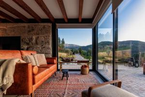 a living room with a couch and a large window at Javardo - Family House - Douro in Penha Longa