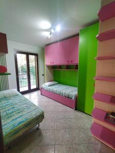 a room with two beds and green and pink walls at 3 bedrooms house with private pool terrace and wifi at Abbateggio in Abbateggio