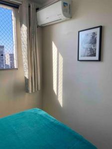 a bedroom with a green bed and a window at Apto Lindo/Aconchegante perto da UEL/bares/ centro in Londrina