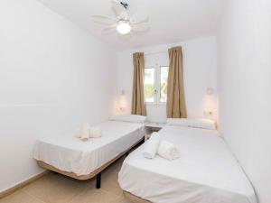 2 camas en una habitación con paredes blancas en Villa Gavines down, en S'Algar