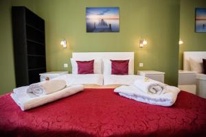 a bedroom with a large bed with towels on it at Di Verdi Imperial Hotel in Budapest