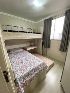 a small bedroom with a bunk bed and a window at Apto Lindo/Aconchegante perto da UEL/bares/ centro in Londrina