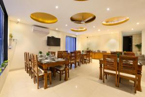 a dining room with a long table and chairs at Denver Paragon Suites Delhi Airport in New Delhi