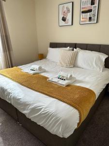 a large bed with two towels on top of it at Yellow Sunflowers Flat In Stroud in Stroud