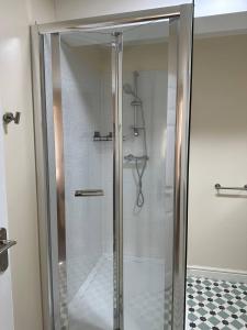 a shower with a glass door in a bathroom at Yellow Sunflowers Flat In Stroud in Stroud