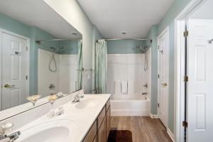 a bathroom with a white sink and a tub at Riverside Relaxation – Golf, Beach & More - Little River, South Carolina in Little River +30 photos