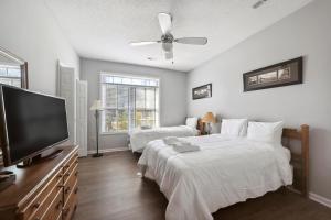 a bedroom with two beds and a flat screen tv at Riverside Relaxation – Golf, Beach & More - Little River, South Carolina in Little River