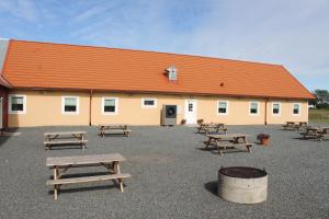 a group of picnic tables in front of a building at Kärraton Vandrarhem in Åhus