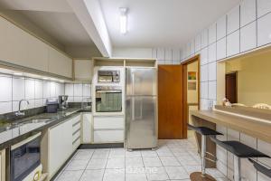 eine Küche mit einem Kühlschrank aus Edelstahl in der Unterkunft Apto c churrasqueira, 50m da praia Itapema EPO001 in Itapema
