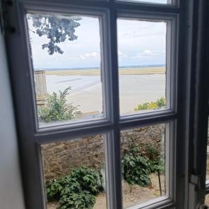 a window with a view of a field seen through it at Chez Adèle in Le Mont Saint Michel