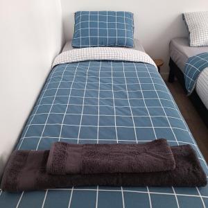 Ce lit se trouve dans un dortoir bleu et blanc. dans l'établissement Chez Adèle, au Mont-Saint-Michel