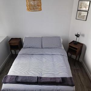 Ce lit se trouve dans une chambre avec 2 tables de chevet et 2 tables. dans l'établissement Chez Adèle, au Mont-Saint-Michel