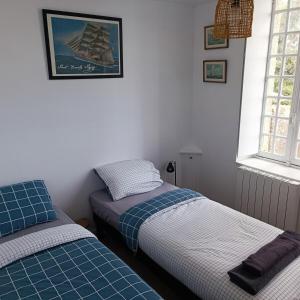 Chez Adèle في جبل القديس ميشيل: غرفة نوم بسريرين وصورة سفينة