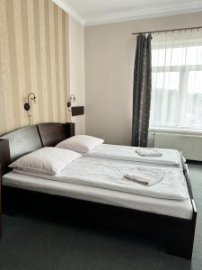 a large bed in a bedroom with a window at Villa Carmen in Kudowa-Zdrój