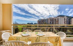 a table on a balcony with a view of a city at Cozy Apartment In Mandelieu-La-Napoule in Mandelieu-la-Napoule
