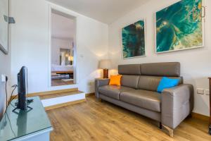 a living room with a couch and a television at Charming home with Sea views & Maltese Balcony by 360 Estates in Valletta