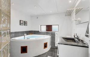 Un baño blanco con bañera y lavabo. en Stunning Home In Humble With Sauna, en Humble 9 fotos más