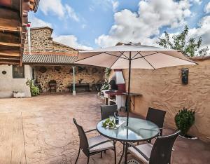 a table and chairs with an umbrella on a patio at Jumaca 