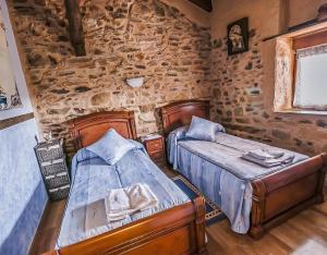 2 Betten in einem Zimmer mit einer Steinmauer in der Unterkunft Jumaca 