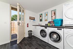 - une buanderie avec un lave-linge et un sèche-linge dans l'établissement Ewe Bach Cottage, à Llanasa 5 autres photos