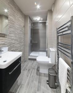 une salle de bain avec un lavabo, des toilettes et une douche dans l'établissement Ewe Bach Cottage, à Llanasa