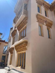 a white building with windows on the side of it at Dgha-Ldhan Guest House in Leh