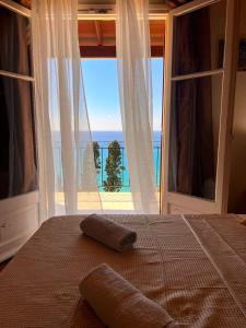 a bedroom with a bed with a view of the ocean at Stefanos Apartments by SV Alians in Agios Gordios