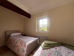 a bedroom with two beds and a window at Dunnaglea Cottage, Ballintoy in Ballintoy