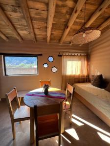 Cette chambre comprend un lit, une table et des chaises. dans l'établissement La Ventanita de Maima, à Maimará
