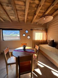 a room with a bed and a table and chairs at La Ventanita de Maima in Maimará