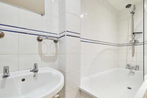 a white bathroom with a sink and a tub at Host & Stay - Roper Road in Canterbury